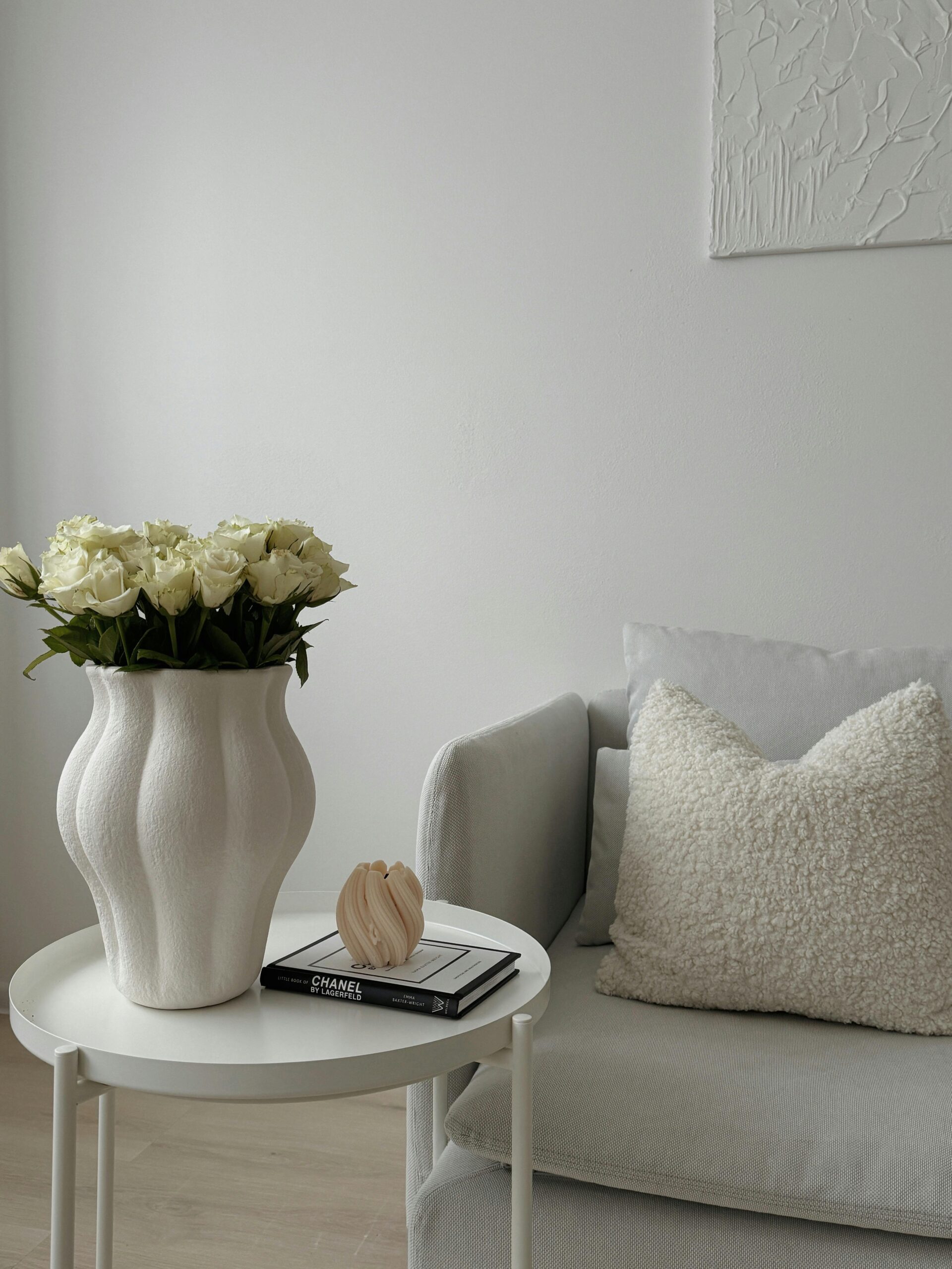 Stylish interior design featuring white roses in a decorative vase on a modern coffee table.